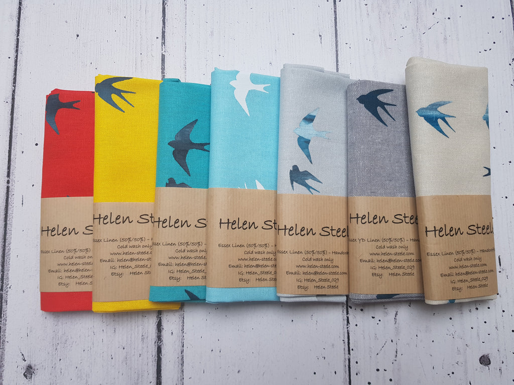 Group of Swallow fabrics in red, yellow, medium aqua, aqua, two greys and a champagne with mixed colour swallows